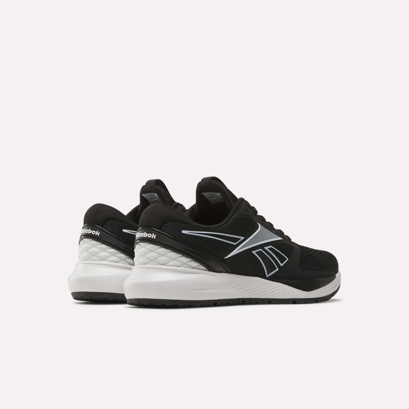 A pair of Women’s NFX Trainer 2 Training Shoes by Reebok in black with white soles, shown from the back and side against a plain white background. The shoes display a white Reebok logo and feature mesh detailing.