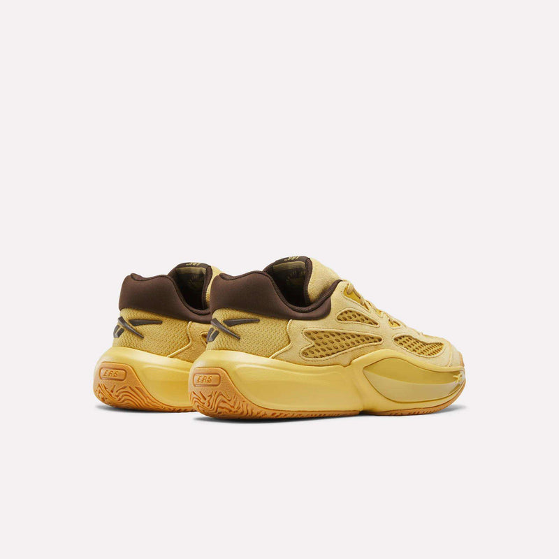A pair of Reebok Engine A 26 Basketball Shoes in yellow and brown, featuring mesh and suede uppers, chunky yellow midsoles for enhanced energy return, and textured orange outsoles designed for stability, displayed on a plain white background.