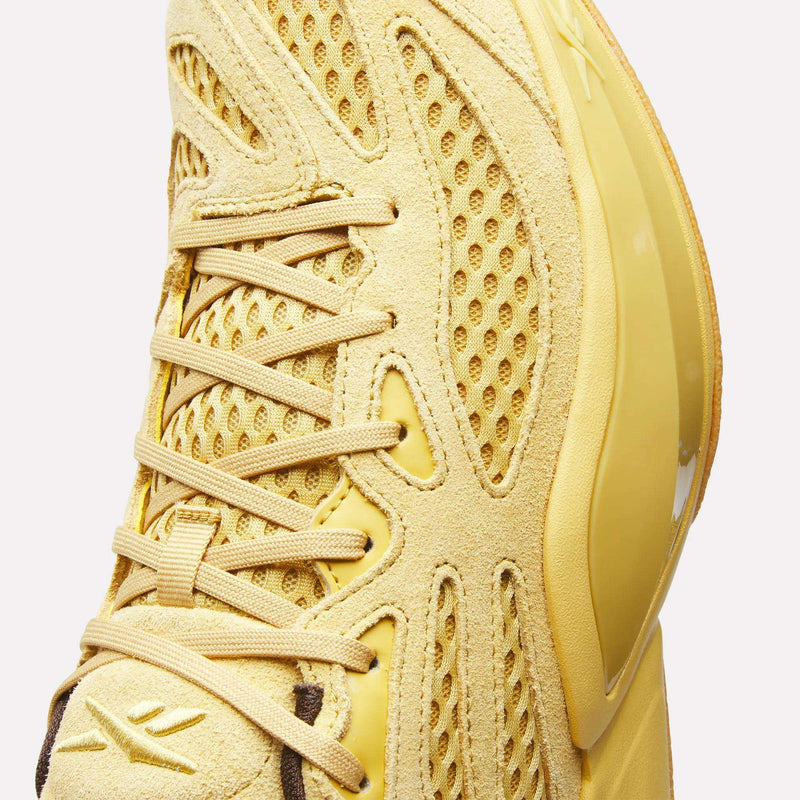 Close-up of the Reebok Engine A 26 Basketball Shoes in yellow, showcasing a mix of mesh and suede textures with matching yellow laces and a glossy side panel. Designed for stability, this style draws inspiration from classic basketball shoes to help keep you secure on your feet.