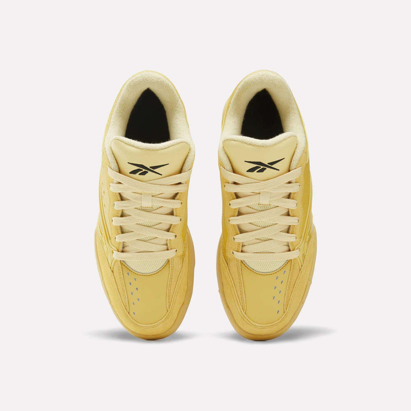 Top-down view of a pair of yellow Reebok Omni Edge low-top sneakers with matching laces and black logo detailing on the tongues.