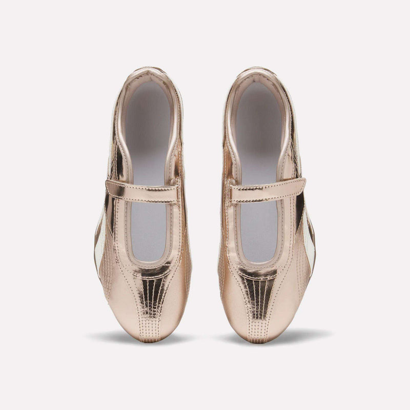 A pair of Reebok Women’s Ultra Lo Mary Jane Shoes in shiny metallic rose gold leather with Velcro straps, photographed from above on a plain white background.