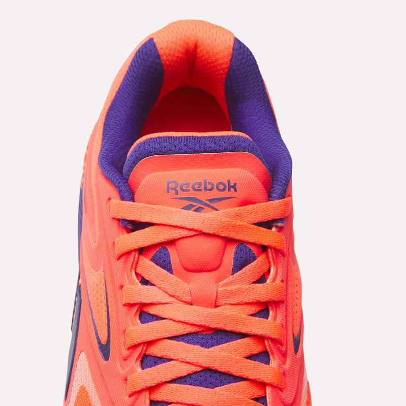 Top view of Reebok Women's Nano X5 Edge Training Shoe in bright orange and purple with orange laces, purple inner lining, and the Reebok logo on the tongue—ideal for your next HIIT class.