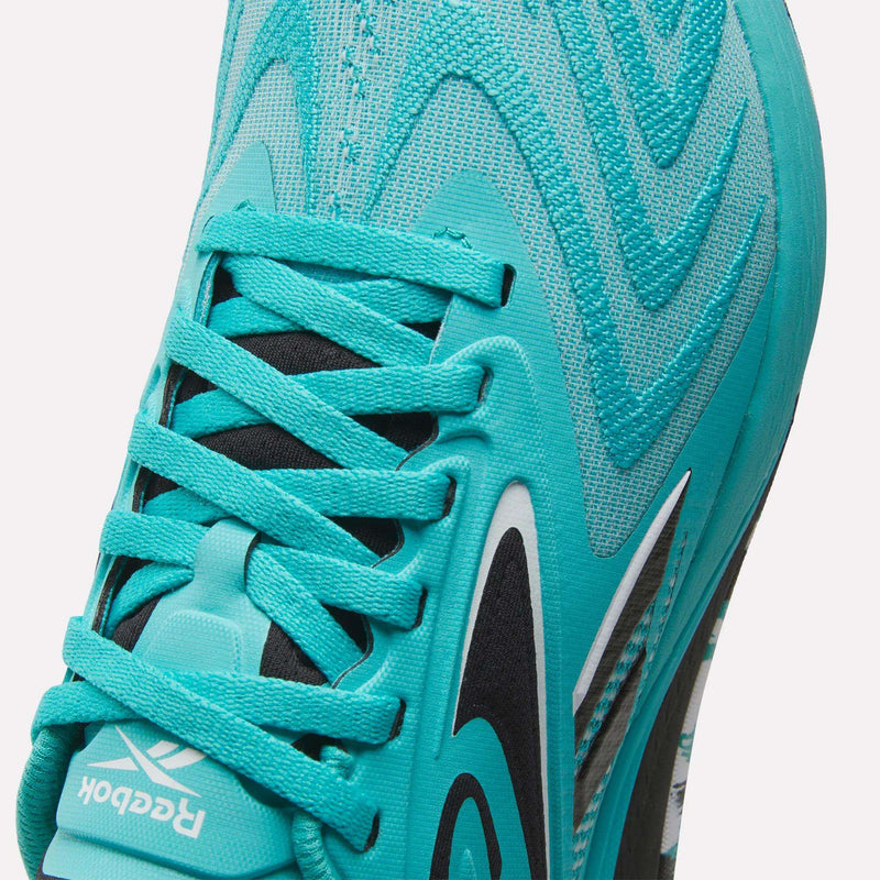 Close-up of Reebok Women's Nano X5 Edge Training Shoes in turquoise, highlighting the laces, Reebok logo on the tongue, and wave-like pattern—perfect for HIIT classes and dynamic workouts.