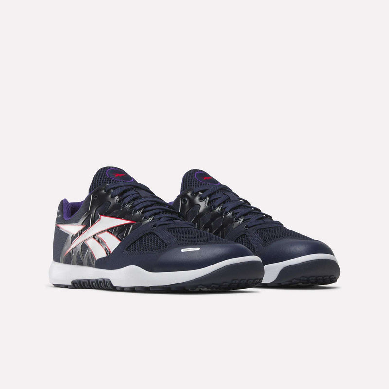 A pair of Reebok Men’s Nano 2.0 Training Shoes in navy blue, featuring white soles, bold white Reebok side logos, black and purple accents, and mesh detailing for breathability—designed for functional fitness—shown against a plain white background.
