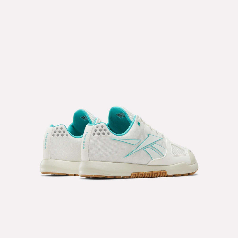 The Reebok Women’s Nano 2.0 Training Shoes are shown from the back and side on a plain white background, featuring a white design with teal accents and gum soles—perfect women’s training shoes designed for functional fitness.