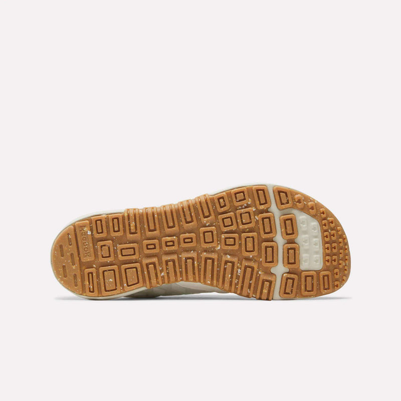 A close-up of the outsole from Reebok’s Women’s Nano 2.0 Training Shoes reveals a brown tread with square and rectangular patterns, accented by a white heel section—perfect for anyone looking for functional fitness footwear.