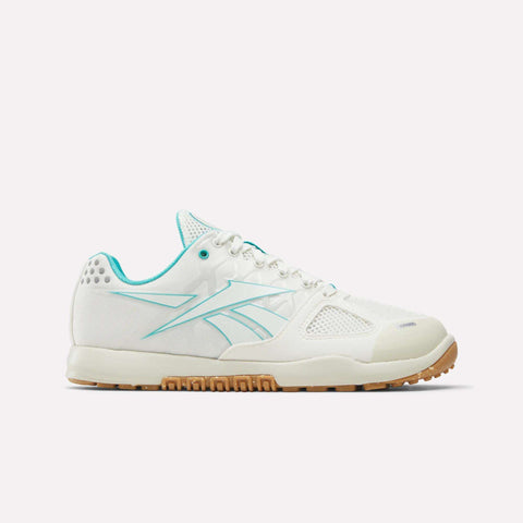 The Reebok Women’s Nano 2.0 Training Shoes—shown in chalk, linen, and gum—feature mesh detailing, light blue accents, and a tan rubber sole. Displayed from the side against a plain white background, these shoes are designed for women’s functional fitness routines.