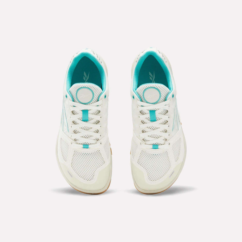 A pair of Reebok Women’s Nano 2.0 Training Shoes in white with turquoise accents, seen from above, featuring mesh uppers, laces, and logo details on the tongues—ideal women’s training shoes crafted for functional fitness.