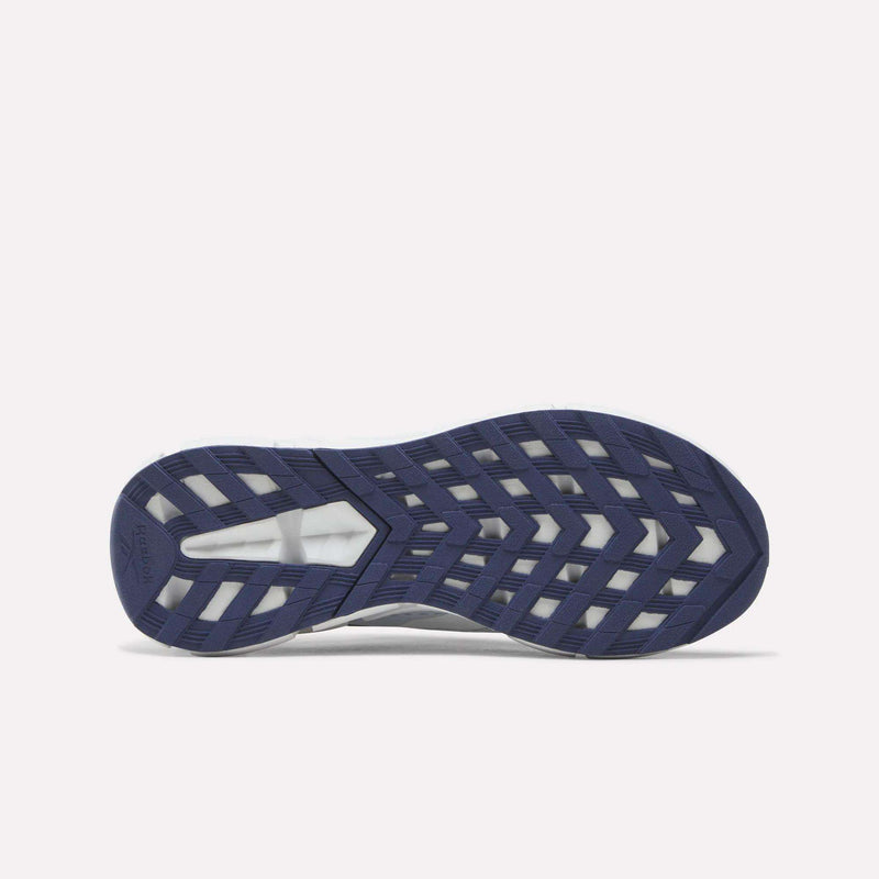 Navy blue and white shoe sole with a geometric tread pattern, photographed from the bottom against a white background to highlight the innovative Zig technology featured in the Reebok Zig Dynamica 6 Running Shoes for big kids.