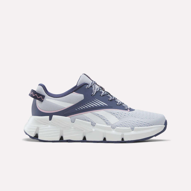 A pair of Reebok Zig Dynamica 6 Running Shoes for big kids in Legacy Blue, Tranquil Blue, and Expressive Pink, featuring mesh fabric construction, patterned laces, and a thick segmented white sole with advanced Zig technology—displayed on a light background and ideal for those after dynamic energy return.