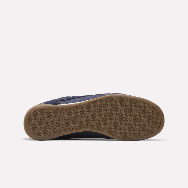 A brown rubber sole with a hexagonal tread pattern, seen from the bottom against a white background. The Reebok name and logo are embossed near the heel, emphasizing its association with the Women’s Freestyle Lo Shoes by Reebok.