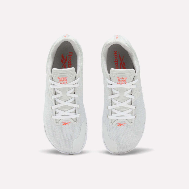 A pair of white Reebok Nano Zero Training Shoes, shown from above on a plain white background, feature red Reebok branding on the tongue and insole, white laces, a breathable mesh upper, and a zero-drop design.