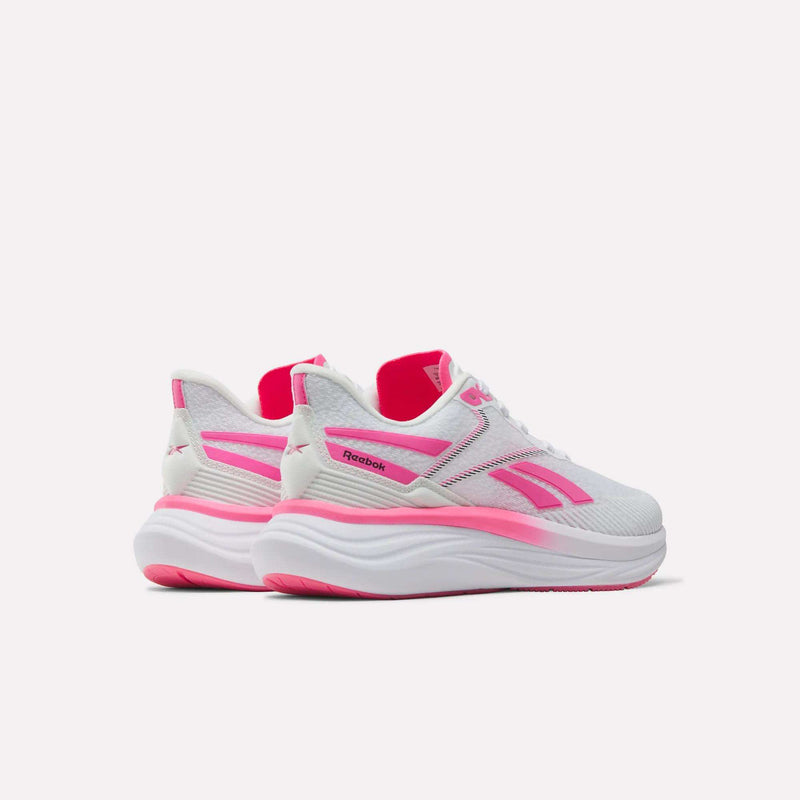 A pair of Reebok Women's Viva Speed Shoes in white with bright pink accents on the sides, sole, and lining are displayed side by side against a plain light background. These shoes offer breathable comfort and style for everyday wear.