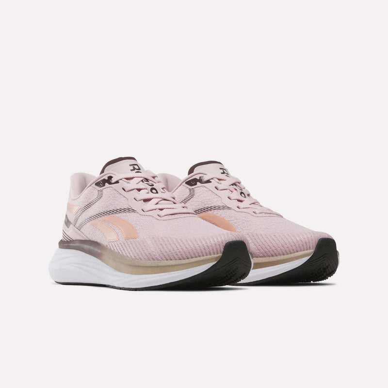 A pair of Women's Viva Speed Shoes by Reebok in light pink, featuring white midsoles, black outsoles, and peach accents. These breathable and cushioned running shoes are displayed against a plain white background.