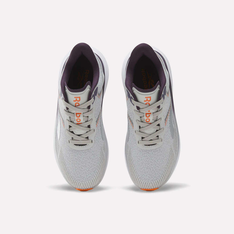 Top view of a pair of Reebok Women's Viva Speed Shoes in light gray with purple accents, featuring an orange logo on the tongue, white laces, and lightly patterned mesh uppers, placed side by side on a plain white background. These breathable running shoes offer a cushioned midsole for enhanced comfort with every stride.