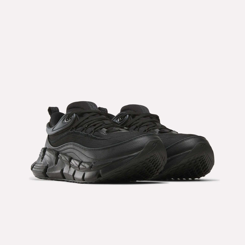 A pair of Reebok Floatzig Encore Running Shoes in an all-black colorway featuring chunky, thick, textured soles and layered detailing, designed for walking and fitness, displayed on a plain white background.