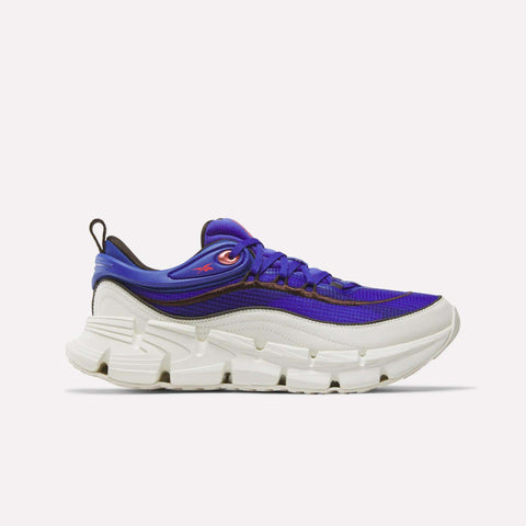 Introducing the Reebok Floatzig Encore Running Shoes—athletic sneakers designed for walking and fitness, featuring a chunky white sole with a Chalk/Neon Cherry/Breakout Blue colorway. Highlighting bold blue accents and neon cherry details, these shoes embody the innovative Zig tech look by Reebok. Displayed against a plain white background.