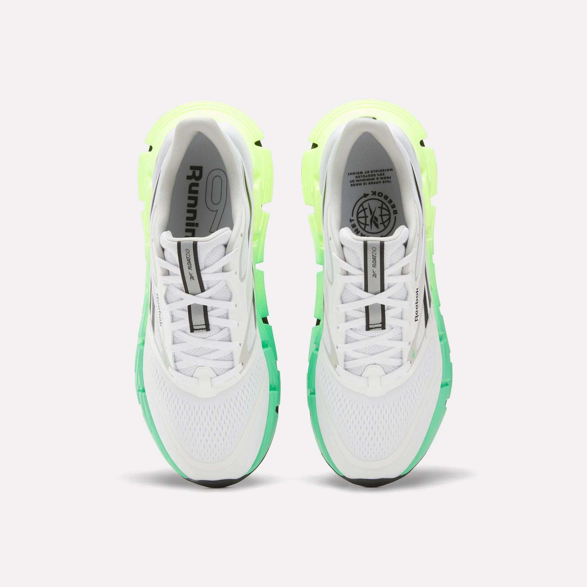 A top view of Reebok Men's FloatZig 2 Running Shoes in white with light green and neon yellow accents, Superfloat+ cushioning, black soles, and branding on the tongues and insoles, set against a plain white background.
