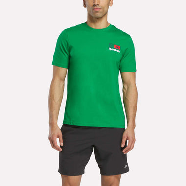 A man in a green Reebok Mexico Football T-Shirt and black shorts stands facing forward against a plain white background.
