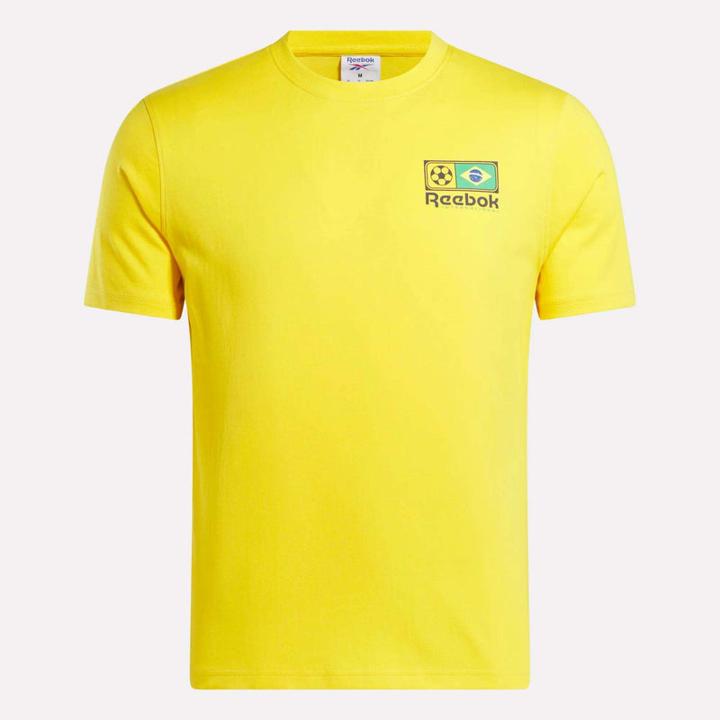 The Reebok Brasil Football T-Shirt is a yellow cotton tee featuring a small left chest graphic with a soccer ball, Brazilian flag, and the Reebok logo.
