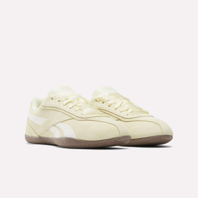 A pair of Women’s Ultra Lo Shoes by Reebok in beige, crafted with a suede upper, white side stripes, and gum soles, displayed against a plain white background.