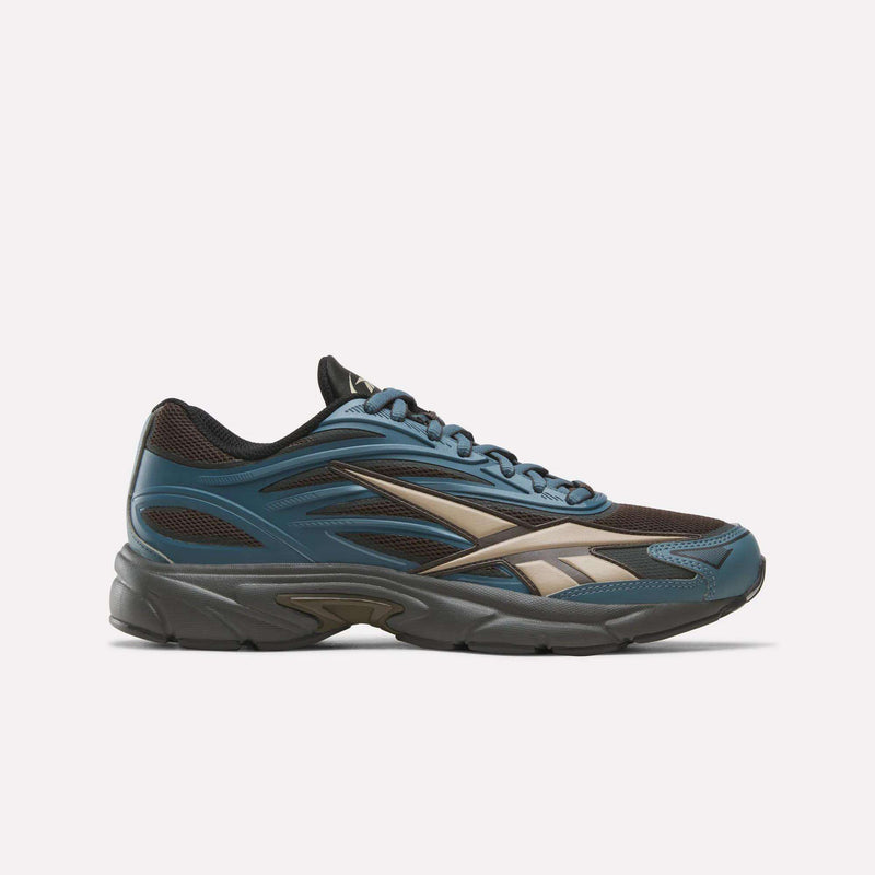 Reebok Premier Road 1000 shoes in a low-top silhouette, featuring a dark blue and brown mesh upper, a beige side logo, and a dark grey midsole.