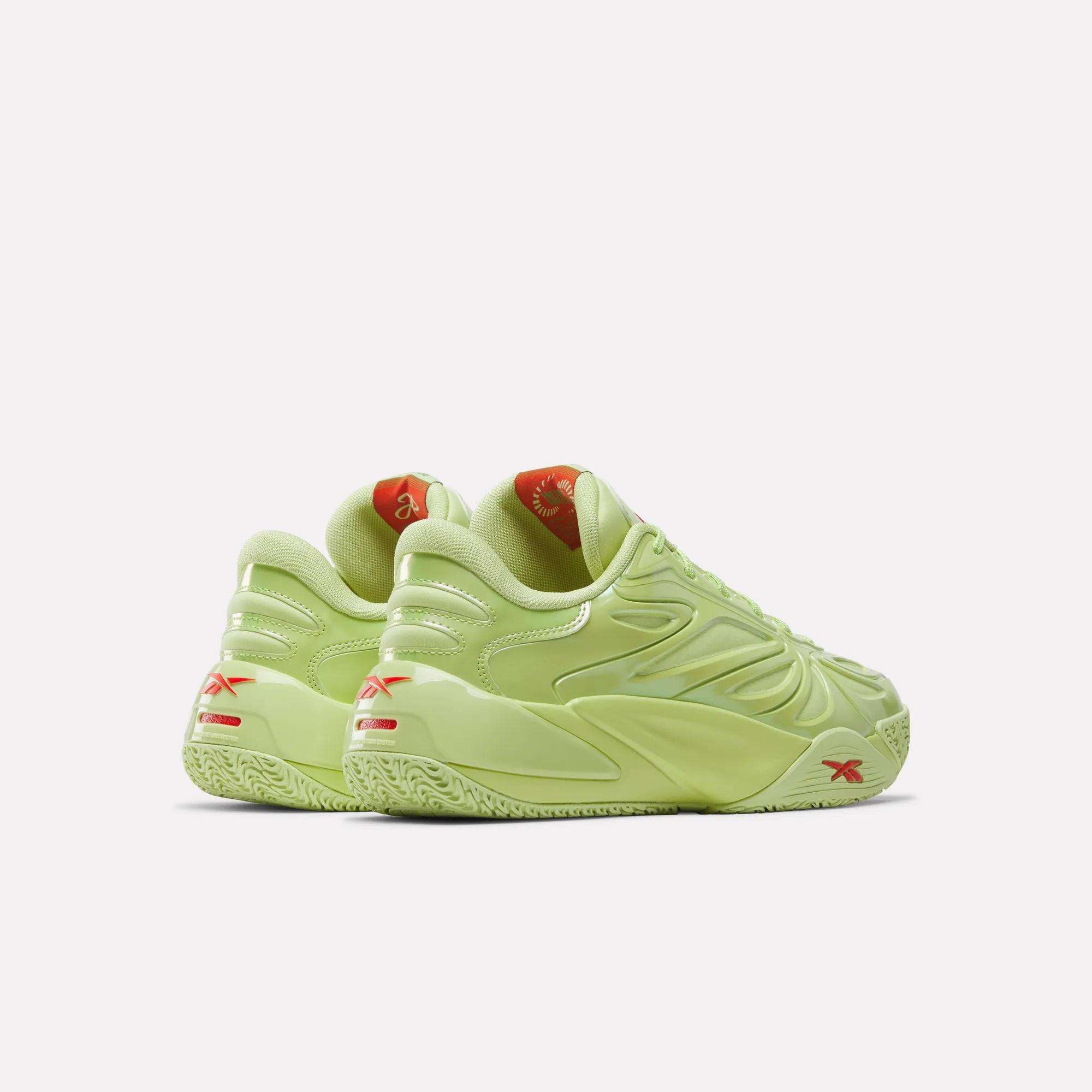 A pair of Reebok Angel Reese 1 Basketball Shoes in light green with chunky soles, red logo accents, and reflective details, showing heels and sides against a plain white background.