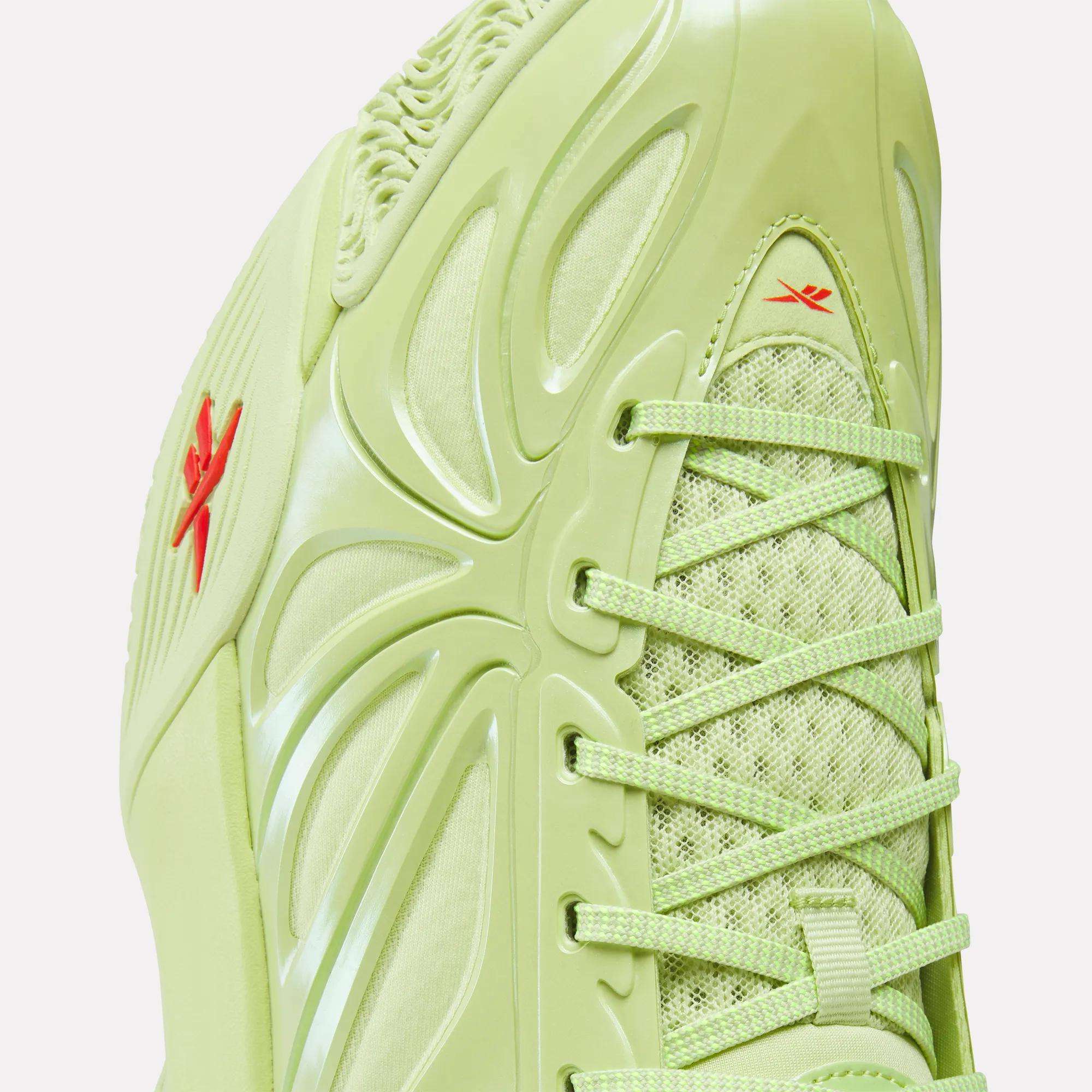 Close-up of the Reebok Angel Reese 1 Basketball Shoes in light green, with textured laces, mesh upper, glossy side panels, two small red Reebok logos, and Energy Return System technology inspired by Angel Reese.