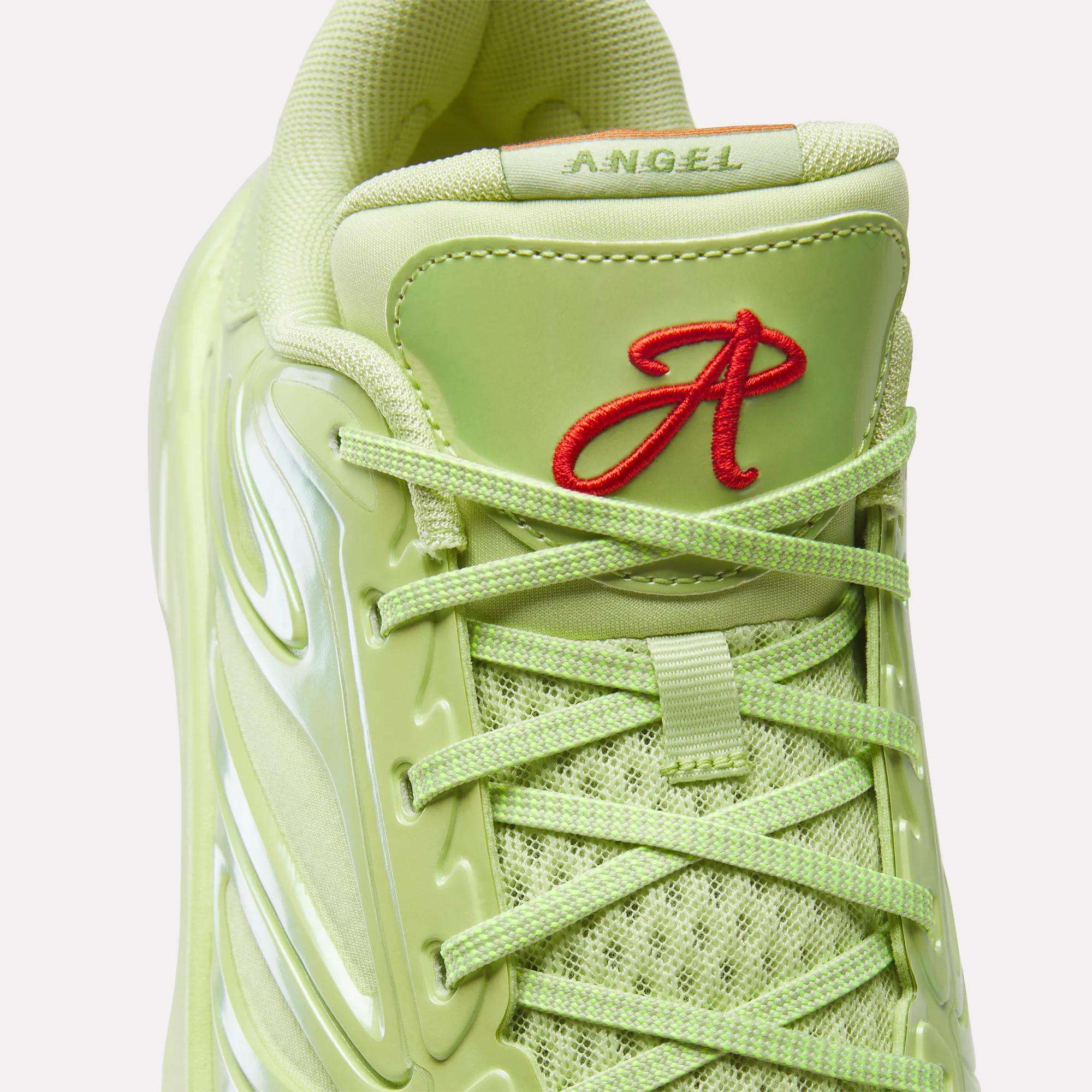 Close-up of a light green Reebok Angel Reese 1 Basketball Shoe with mesh, shiny details, green laces, and a red embroidered A and "ANGEL" on the tongue—highlighting its performance basketball shoe inspiration.