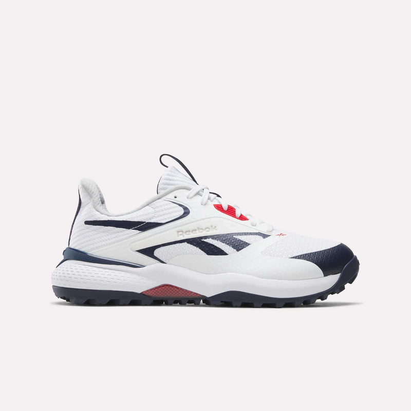 The Reebok Nano Golf Shoes are white athletic sneakers with navy blue and red accents, featuring a low-top design, mesh and synthetic upper with lightweight FlexWeave, and the signature Reebok logo on the side.