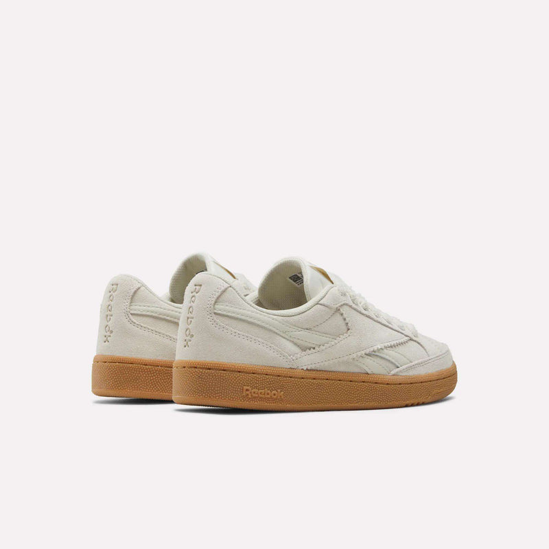 A pair of Women’s Club C Grounds 70 Shoes by Reebok, featuring an off-white suede upper and classic gum soles, are positioned side by side, facing slightly left, on a plain white background.