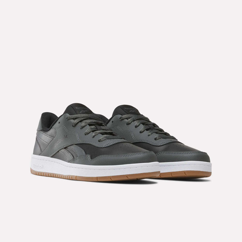 A pair of Reebok Men’s BB 1000 Shoes in dark gray, showcasing the classic side-stripe design with white soles and gum bottoms, displayed against a plain light background.