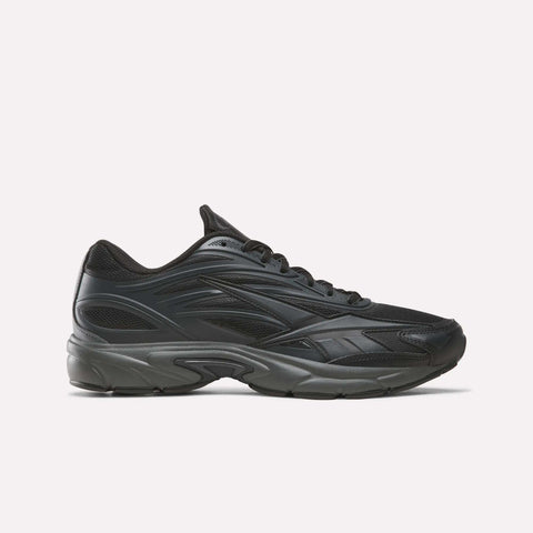 The Reebok Premier Road 1000 Shoes in Almostblack/Black are athletic sneakers inspired by retro running styles, featuring a chunky dark sole, a mesh upper, and sleek wavy design lines, shown in profile against a plain light background.