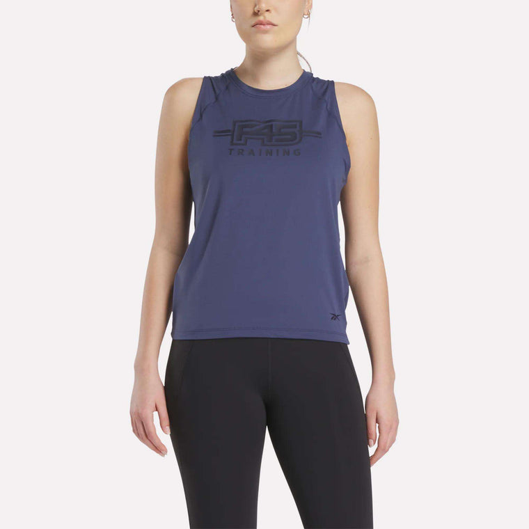 A woman wears the Women's Reebok x F45 Training Tank Top in navy and black leggings, standing facing forward against a plain white background.