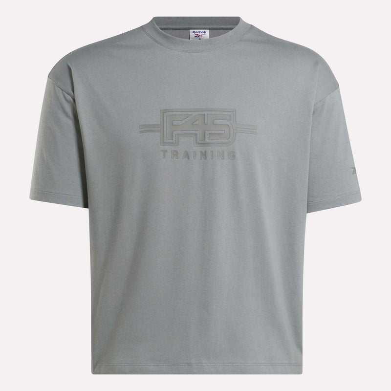 The Reebok x F45 Training Tonal Graphic T-Shirt is a light gray cotton tee with short sleeves, a relaxed fit, and a crew neckline, featuring the F45 TRAINING logo in matching gray on the front.