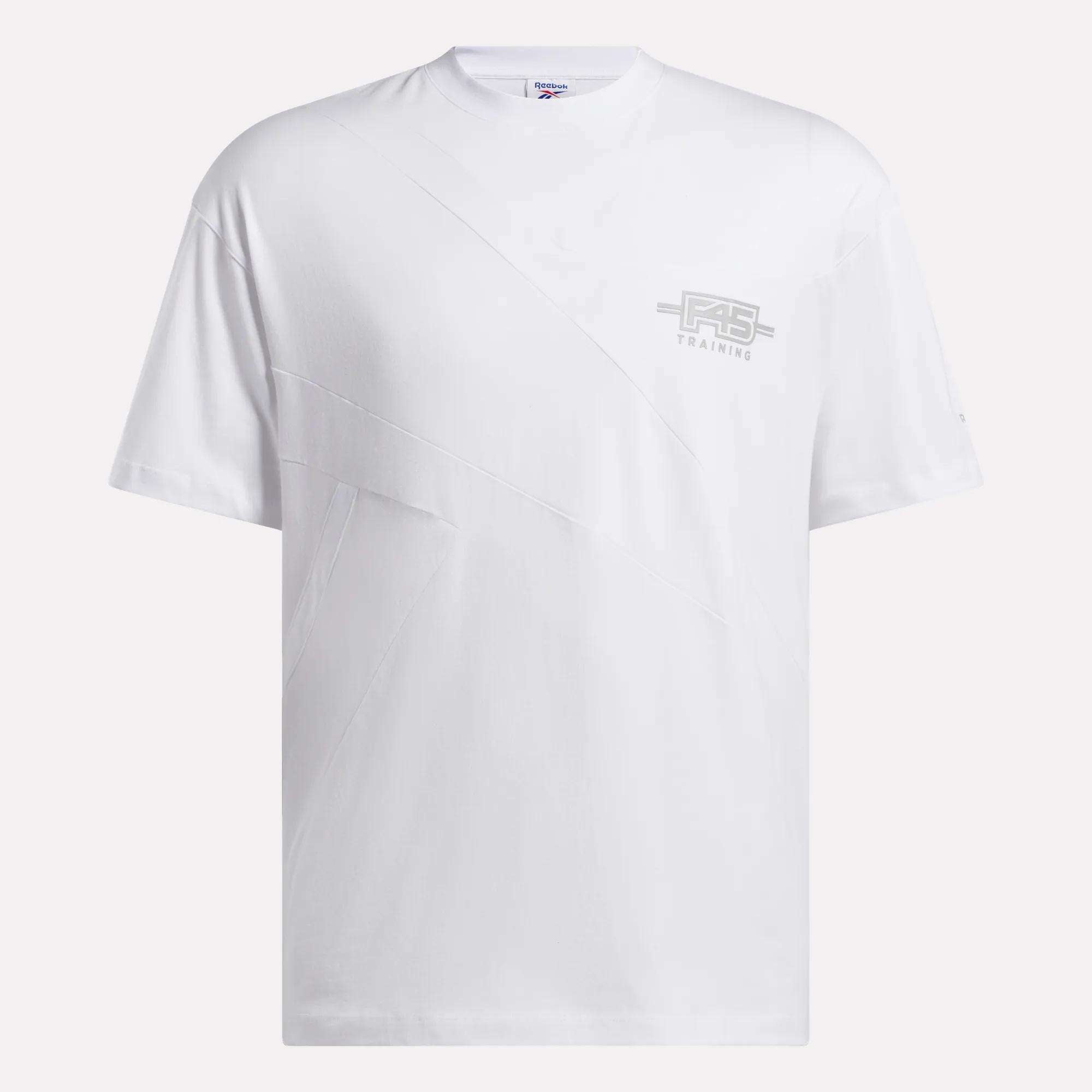 The Reebok x F45 Training Relaxed T-Shirt is a plain white tee with subtle diagonal stitching and a small light gray Reebok logo on the left chest, ideal for F45 Training or casual wear. Displayed on a clean white background.