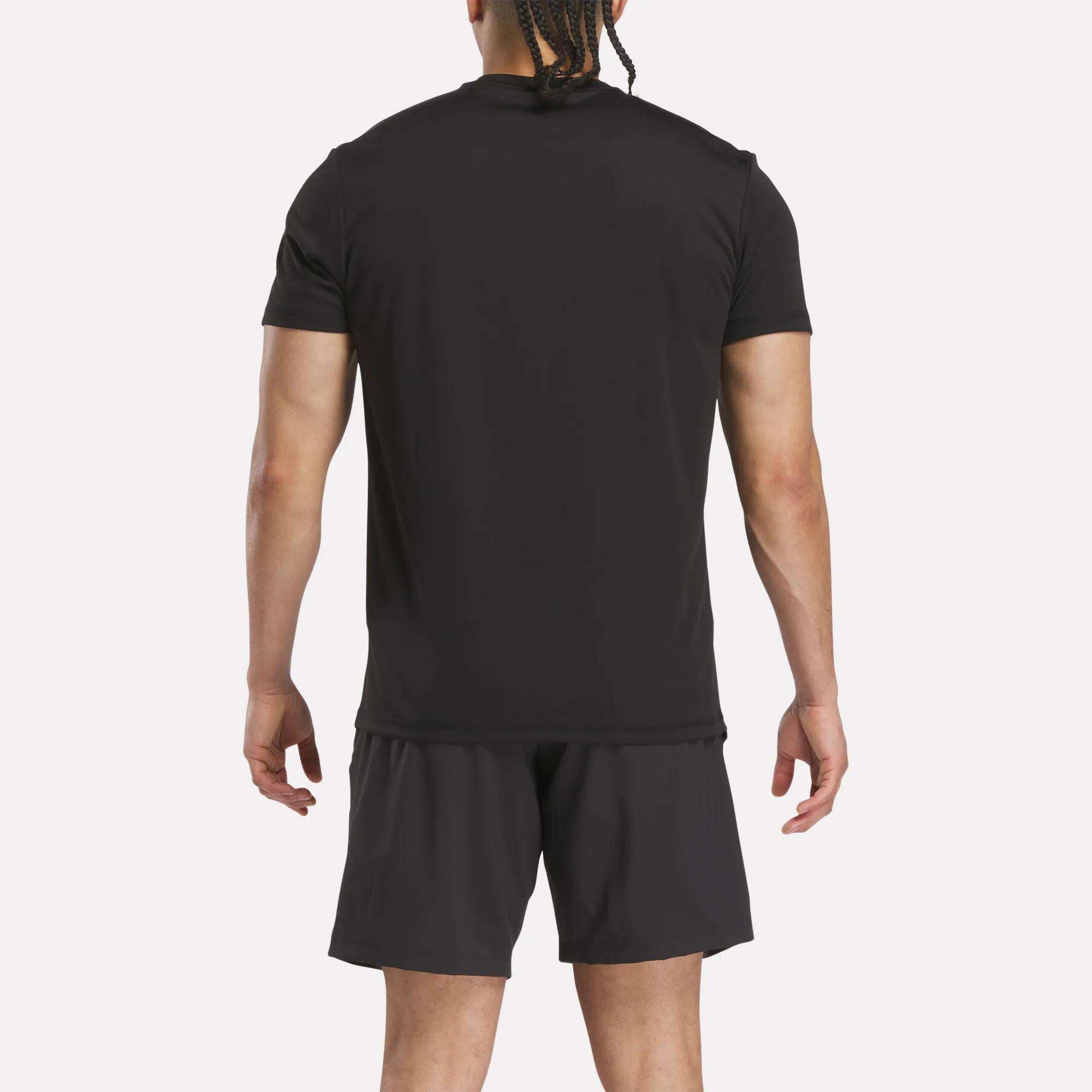 A person stands facing away from the camera, wearing a Reebok Men’s Reebok x F45 Training T-Shirt and black shorts against a plain white background.