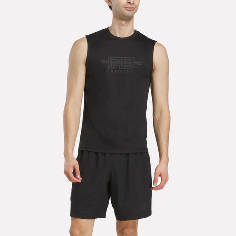 A man wears a black Men’s Reebok x F45 Training Tank Top with a gray logo on the chest, paired with matching black athletic shorts.