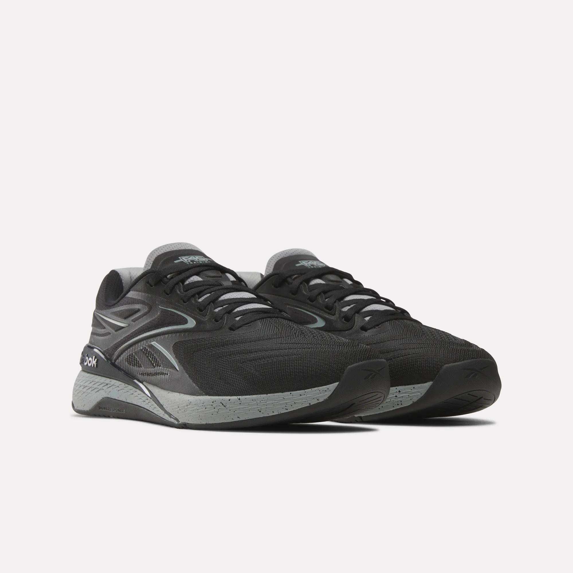 A pair of Reebok x F45 Nano X5 Edge performance training shoes in black and gray with mesh uppers, gray accents, and speckled midsoles from Reebok, shown against a plain white background.