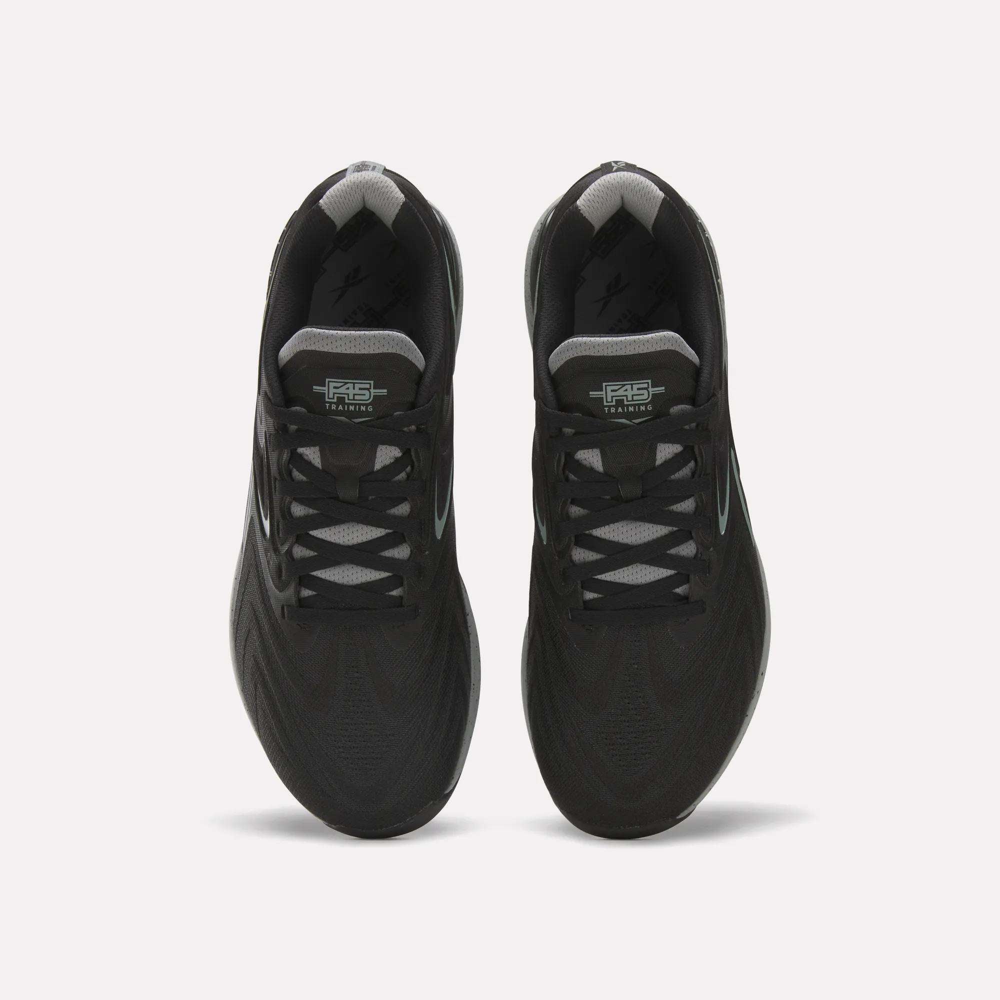 Top view of the Reebok x F45 Nano X5 Edge training shoes by Reebok in black with gray laces and patterned mesh, side by side on a white background.