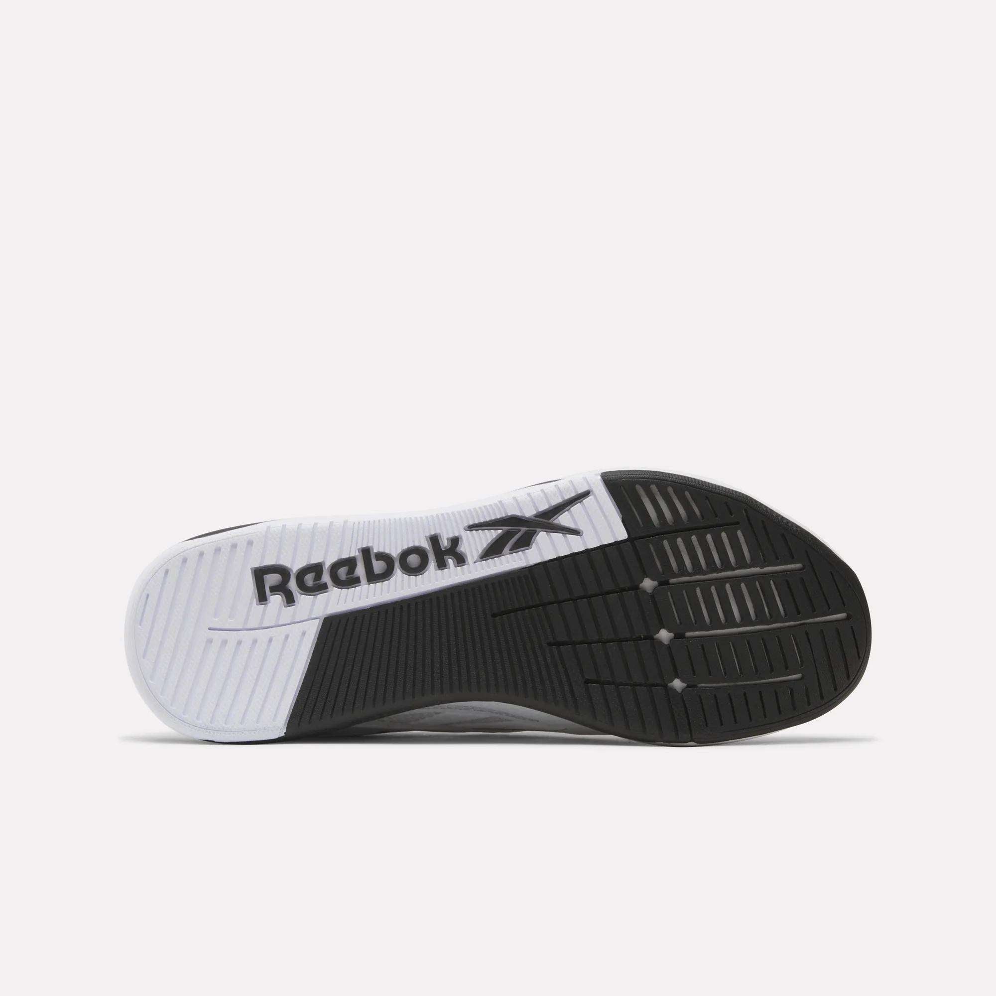 The image displays the black and white rubber outsole of the Reebok x F45 Nano X5 Edge, with the Reebok logo at midfoot. Its varied tread pattern ensures optimal traction, making it ideal for performance training shoes.