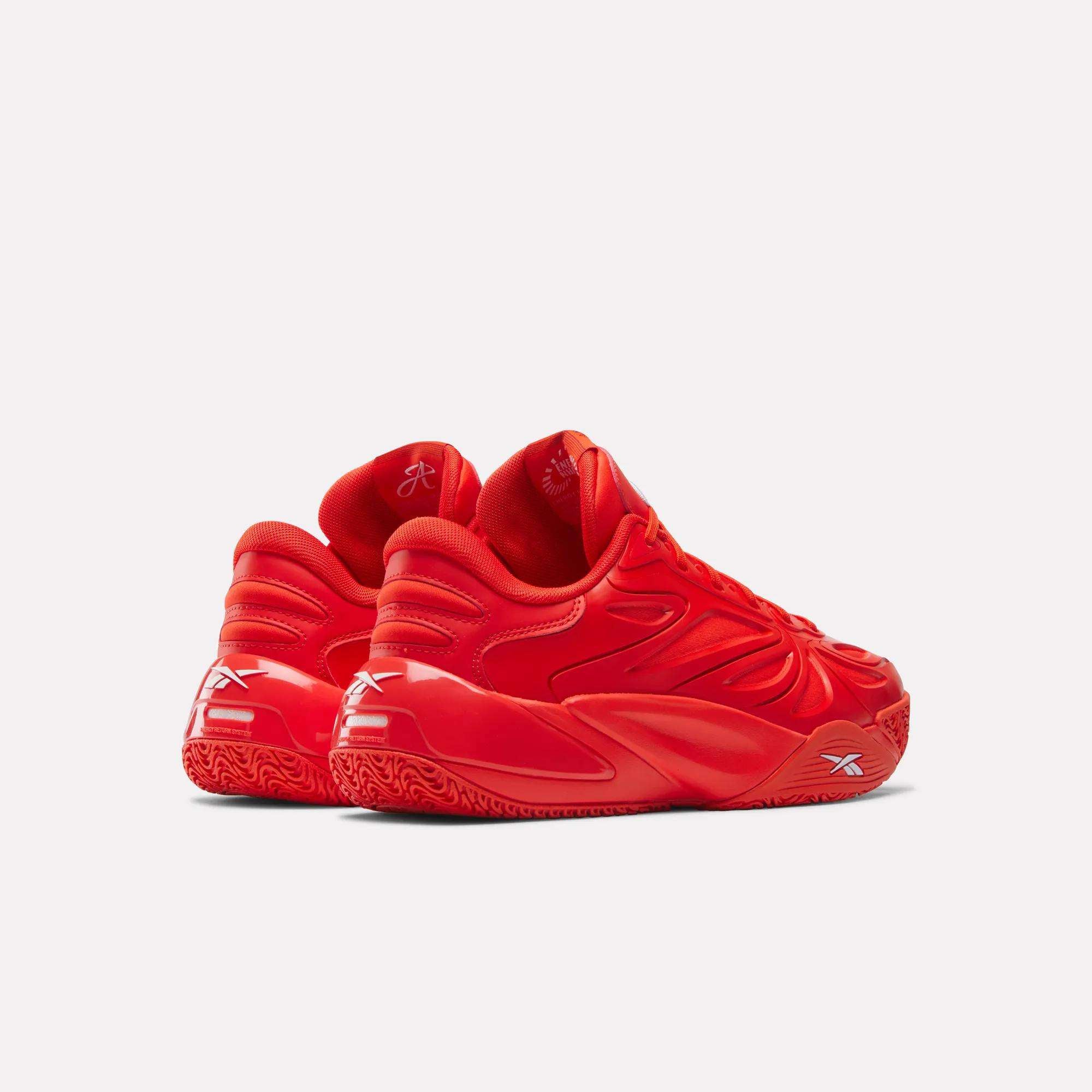 A pair of vibrant red Reebok Angel Reese 1 Basketball Shoes with Energy Return System, textured soles, curved accents, and white Reebok logos on the sides and back, displayed against a light background.