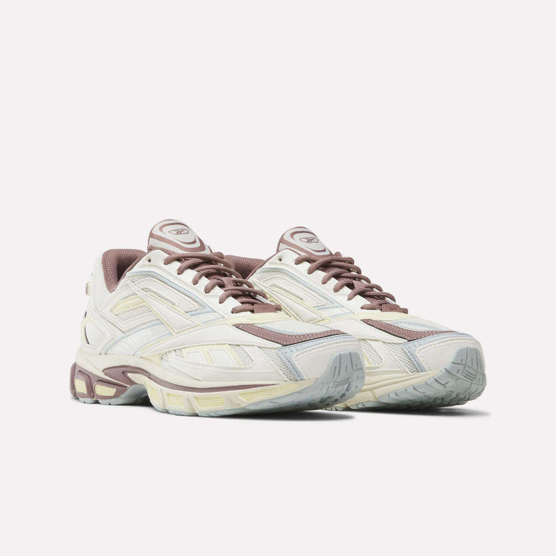 A pair of Reebok Premier Road Ultra SV Shoes in beige and mauve, inspired by Y2K style, featuring detailed paneling, lace-up fronts, and textured rubber soles reminiscent of the classic Premier Road design, displayed on a plain white background.