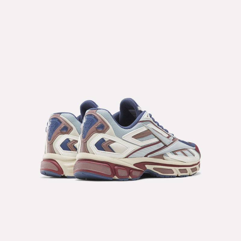 A pair of Reebok Premier Road Ultra SV Shoes featuring blue, cream, burgundy, and silver accents are displayed on a white background with their heels facing slightly outward. These multicolored running sneakers capture the nostalgic vibe of Y2K shoes while blending modern comfort and style.