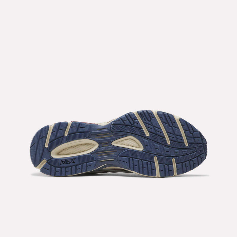 The image shows the bottom view of a sneaker, featuring a blue and beige rubber sole with textured tread patterns—a hallmark of Reebok Premier Road Ultra SV Shoes inspired by iconic Y2K designs.