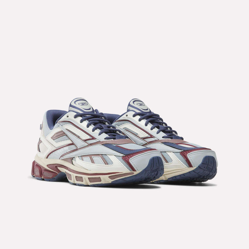 Introducing the Reebok Premier Road Ultra SV Shoes, a pair of athletic sneakers showcasing a blue, maroon, and white color scheme with mesh and synthetic panels, lace-up closures, and chunky soles inspired by classic Y2K designs.