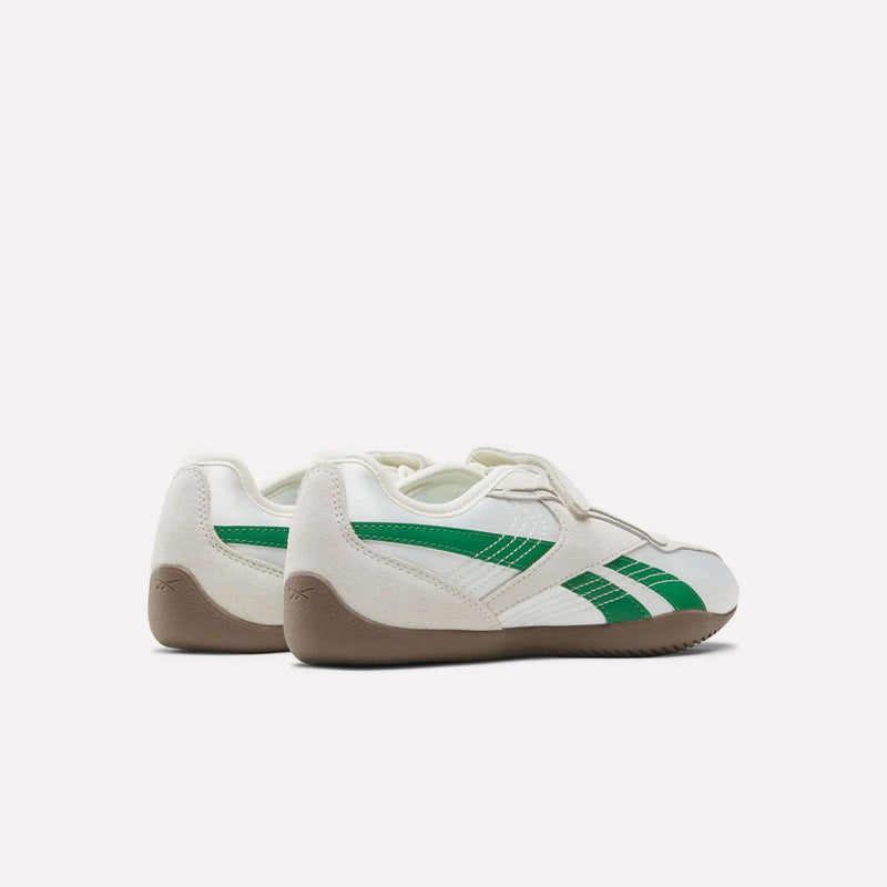 A pair of Reebok Women’s Ultra Lo Mary Jane Shoes in classic white with green stripes and beige soles, featuring a stylish design shown from the back and side angles on a plain light background.