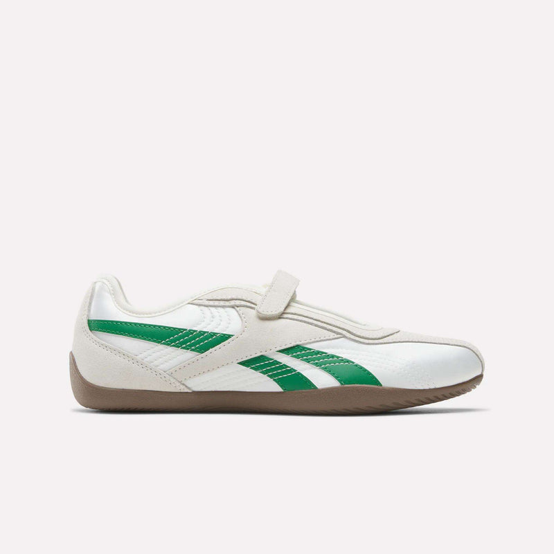 Women’s Ultra Lo Mary Jane Shoes by Reebok, shown in Chalk/Glen Green with a brown sole. This side-view image highlights their classic-inspired design, featuring a velcro strap and a sleek, low-profile silhouette on a plain white background.