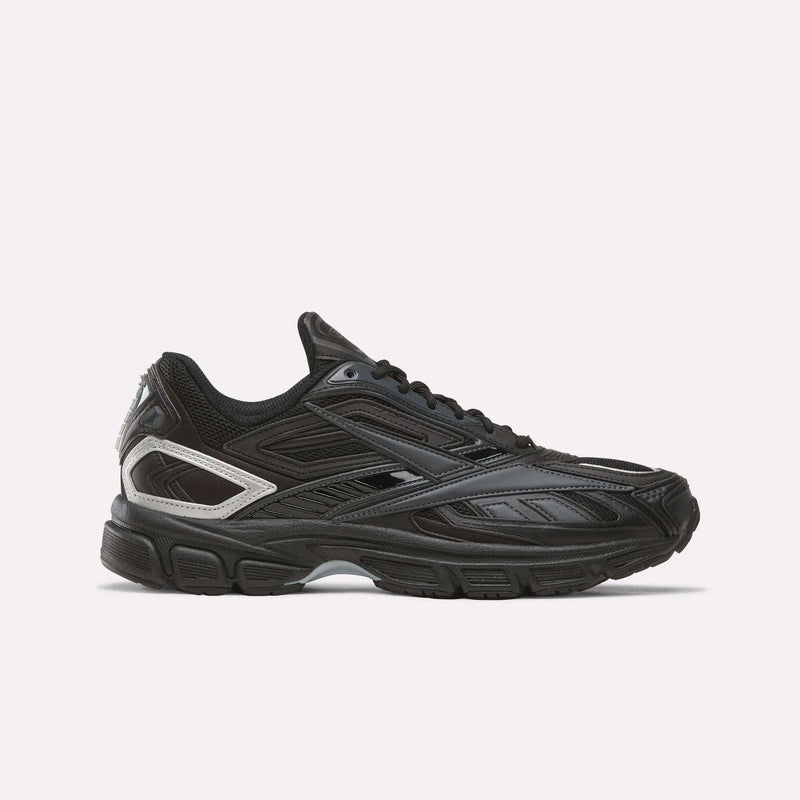 The Reebok Premier Road Ultra SV Shoes in Black/Almost Black/Silver are shown from the side, featuring a textured sole and mesh detailing on the upper, all set against a plain white background. This design takes cues from classic Y2K footwear, skillfully blending retro style with modern comfort to create an ideal pair of running sneakers.