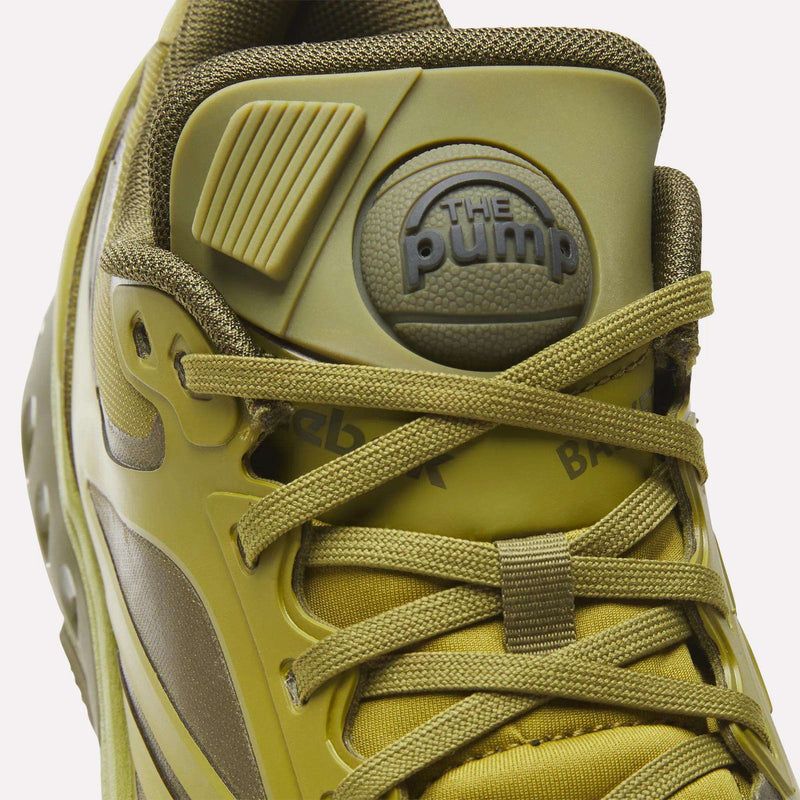 Close-up of an olive green Reebok Engine A Pump shoe featuring the signature Pump technology button on the tongue.